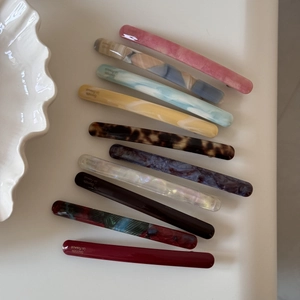Detailed close-up of 10-piece acetate hair clips in diverse French retro patterns