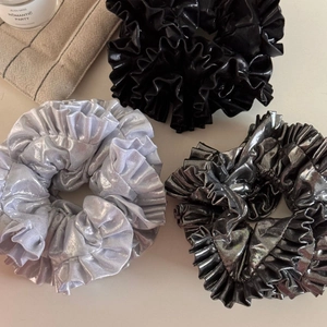 Detail showing metallic textured ruffled scrunchies in silver, black and dark grey tones