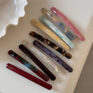Macro detail of ten assorted acetate hair barrettes with marble and tortoiseshell patterns