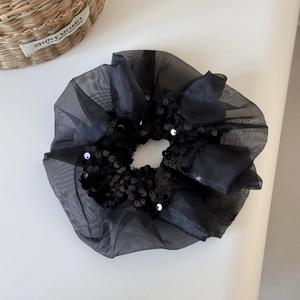 Détails du chouchou en organza noir avec des paillettes scintillantes et de la dentelle
