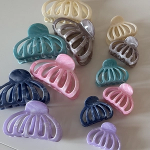 Vue macro de pinces à cheveux à texture marbrée colorée avec design citrouille ajouré