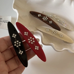 Close-up of vintage flower hair clips with rhinestones and elegant oval spring barrettes