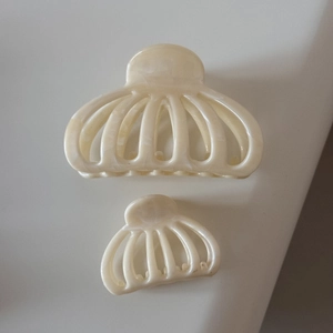 Détail de pinces à cheveux en marbre crème en deux tailles avec un design creux élégant