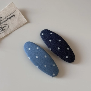 Détail de barrettes en denim à pois bleu marine et clair pour une coiffure décontractée