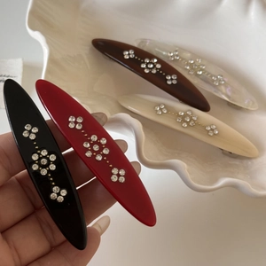 Detailed view of oval spring hair clips featuring sparkling rhinestone flower patterns