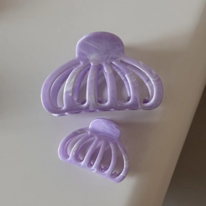 Détail de pinces à cheveux violettes marbrées avec motifs ajourés élégants de citrouille