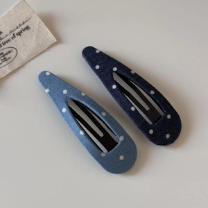 Vue détaillée des barrettes en denim bleu à pois avec base métallique robuste
