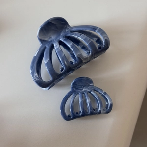 Détail de deux pinces à cheveux texture marbre bleu foncé en grande et petite taille