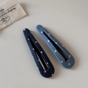 Détail de barrettes à pois en denim bleu avec une texture de tissu délicate