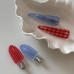 Retro plaid 4-piece hair clip set with red and blue checkered patterns in a ceramic tray