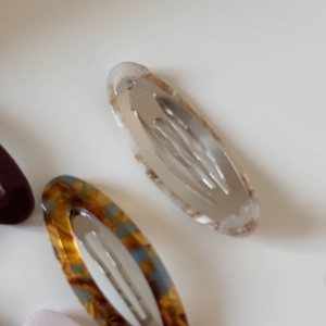 Detailed macro view of acetate hollow oval BB clips with various marble and shell textures