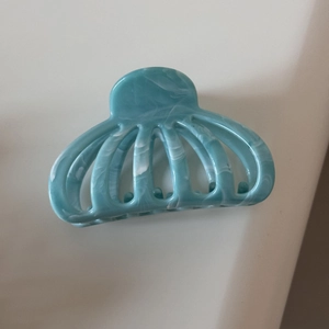 Détail d'une pince à cheveux motif marbre bleu avec design de citrouille évidée