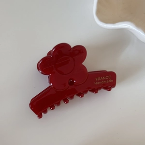 Détail d'une pince à cheveux fleur bordeaux avec lettrage doré FRANCE Handmade