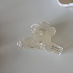 Gros plan détaillé sur la pince à cheveux fleur irisée avec inscription France Handmade