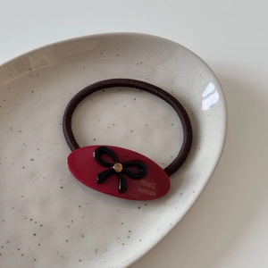 Détail de l'élastique en acétate bordeaux avec nœud noir et texte France Handmade