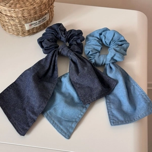 Dettaglio di elastici in denim blu con lunghi fiocchi in tonalità chiare e scure
