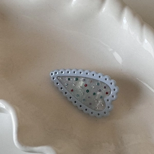 Détail macro de la pince à cheveux en forme de cœur avec cristaux colorés sur plat