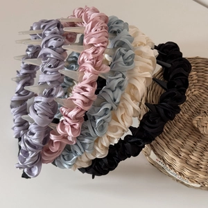 Chic ruched fabric headbands with teeth in assorted Morandi colors on a basket