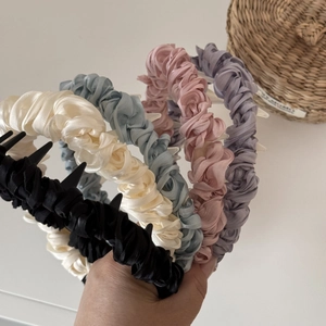 Detail of five colored pleated satin headbands with anti-slip inner plastic teeth grips