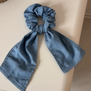 Dettaglio dell'elastico in denim azzurro con fiocco lungo e trama di cucitura pulita