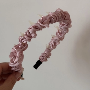 Close-up of pink pleated satin headband with interior anti-slip teeth detail