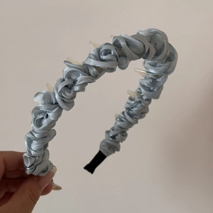 Macro detail of blue satin pleated headband with inner anti-slip teeth design