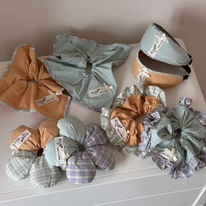 Detail of sweet plaid hair scrunchie with lace bow and authentic woven brand label