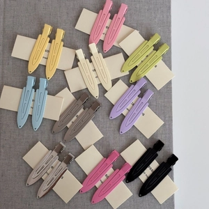 Detailed macro view of 10-color metallic duckbill hair clips set on display cards