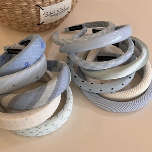 Detailansicht von blau gestreiften Stirnbändern mit handgefertigten Etiketten auf Beige