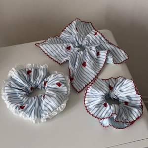 Détail de l'ensemble de chouchous à rayures bleues avec broderie cœur rouge et volants