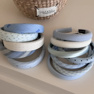 Nahaufnahme von blau gestreiften und gepunkteten Schwammhaarreifen mit Handmade-Etiketten