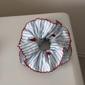Détail du chouchou à rayures bleues avec broderie de coeur rouge et bordure