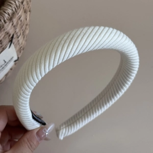 Detail eines weißen Rippstrick-Schwammstirnbands mit seiner dicken und flauschigen Textur