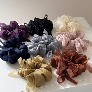 Flat lay of eight colorful chiffon bow scrunchies in varied pastel and neutral tones