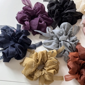 Close-up of chiffon scrunchies in multiple colors with delicate pleated texture