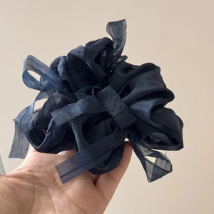 Close-up of fluffy navy blue chiffon scrunchie with elegant layered texture for hair