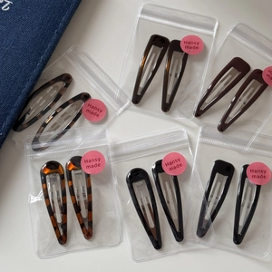 Detailed view of leopard print BB hair clips in tortoise shell and solid colors