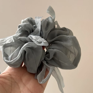 Detail of airy chiffon scrunchie with layered pleats in smoky grey ballet style