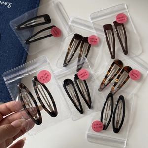 Close-up of leopard pattern hair clips in pairs with transparent packaging and silver metal base