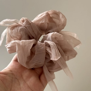 Close-up of pink puff chiffon scrunchie with delicate pleats and translucent texture