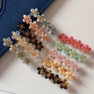 Lot de barrettes à fleurs en acrylique multicolore avec détails dorés sur fond blanc
