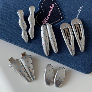 5 paires de pinces à cheveux argentées à pois bleus sur un fond en tissu denim tendance