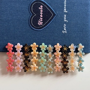 Lot de barrettes à fleurs colorées avec centre d'étoile dorée sur fond en denim