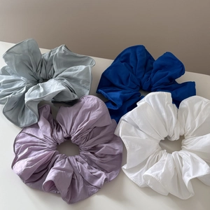 Flat lay of colorful ruffled hair scrunchies in blue, purple and white fabrics