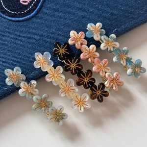 Vue détaillée des barrettes fleurs avec texture marbrée nacrée et centres dorés élégants