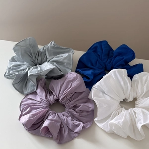 Set of four oversized fabric scrunchies in gray, navy blue, light purple, and white colors