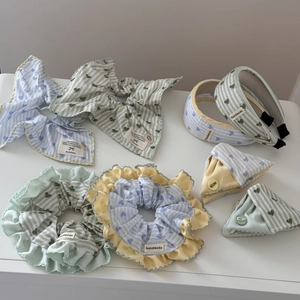 Detailed flat lay of blue and green striped fabric hair accessories with heart patterns