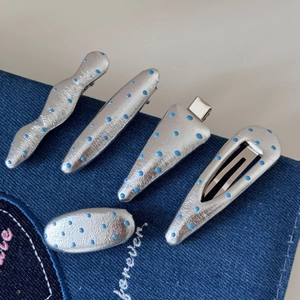 Set de 5 pinces à cheveux en cuir argenté à pois bleus sur fond en tissu denim foncé