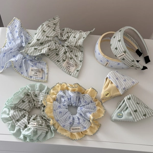 Blue and green striped scrunchies and hair clips with heart patterns and ruffled edges