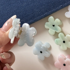Detail showing colorful floral hair claws with smooth finish and spring mechanism detail